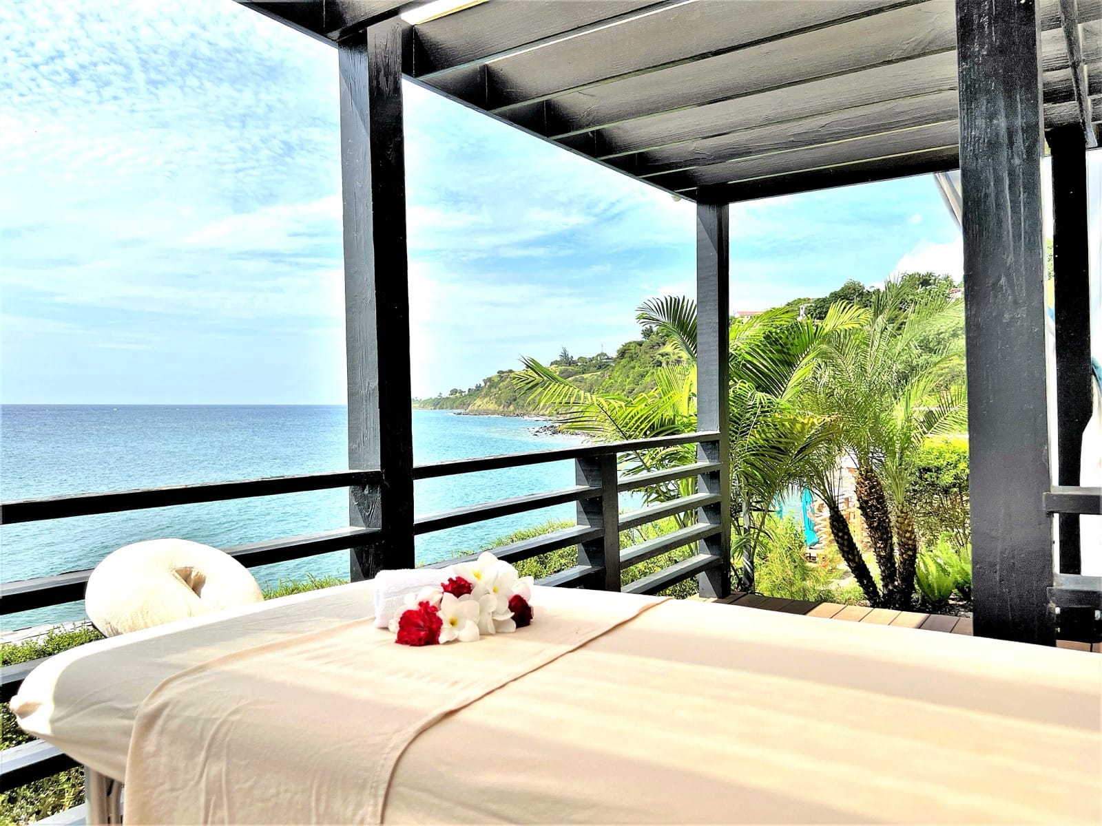 A massage table on the covered deck, looking out over the Caribbean Sea