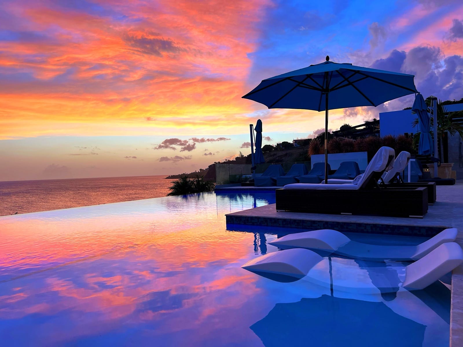 Loungers beside the infinity pool at sunset